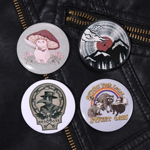Detailed view of four tinplate badges with mushroom and raccoon pins on a black leather jacket