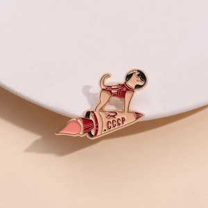 Laika Soviet space dog brooch featuring a CCCP rocket with golden enamel finish