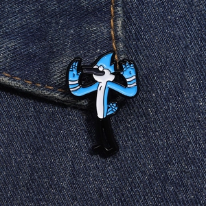 Dettaglio della spilla smaltata Mordecai su denim che mostra finiture metalliche e colori