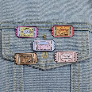 Detailed close-up of colorful movie ticket enamel pins on a denim jacket pocket