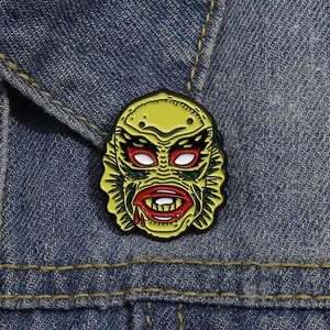 Close-up of the Creature from the Black Lagoon monster enamel pin on denim jacket