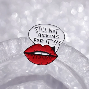 Detail of red lips enamel pin featuring Still Not Asking For It text in a speech bubble