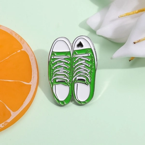 Creative green canvas shoe enamel brooch with black heart design on fresh floral background