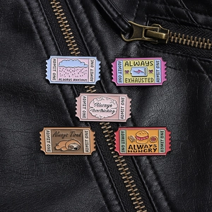 Detail of five enamel pins with movie ticket designs pinned to a black leather jacket