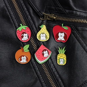 Set of six colorful cat and fruit enamel pins displayed on a black leather jacket