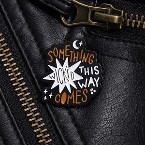 Detail of Something Wicked This Way Comes enamel pin on a black leather jacket