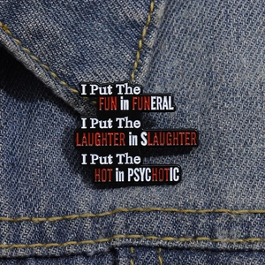 Macro shot of black enamel funeral pin pinned on a blue denim jacket texture