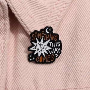 Detail of Something Wicked enamel brooch pinned on pink denim fabric collar