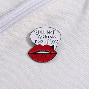 Detail of STILL NOT ASKING FOR IT enamel pin with red lips on a canvas bag strap