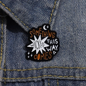 Detail of Something Wicked This Way Comes enamel pin on a blue denim jacket collar