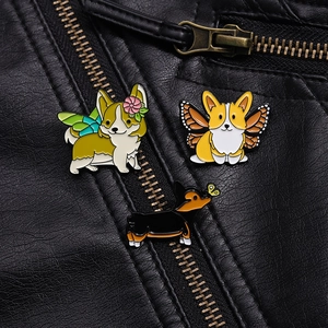 Dreiteiliges Set Cartoon-Corgi-Emaille-Pins mit bunten Flügeln auf schwarzem Lederhintergrund