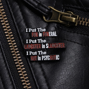 Close-up of a black enamel pin with humorous English quotes on a leather jacket zipper