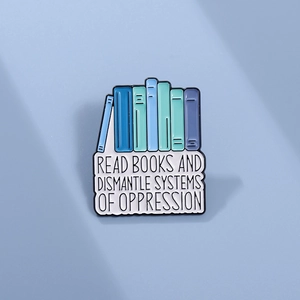 Enamel pin with colorful books and the text READ BOOKS AND DISMANTLE SYSTEMS OF OPPRESSION