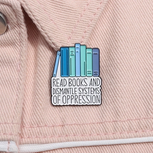 Detail of enamel book pin with 'Read Books' slogan on pink denim jacket texture