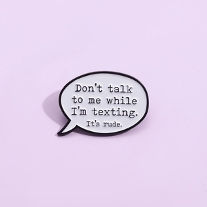 Détail d'un pin's bulle de texte en émail sur un fond violet doux et élégant