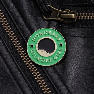 Gros plan du pin's émaillé Honorary Gilmore Girl sur une veste en cuir noir