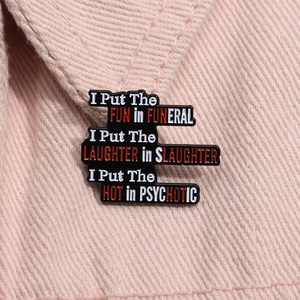 Detail of a funny quote enamel pin in black and red on pink denim jacket texture