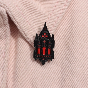 Close-up of a Gothic cathedral enamel pin in black and red on a pink denim collar