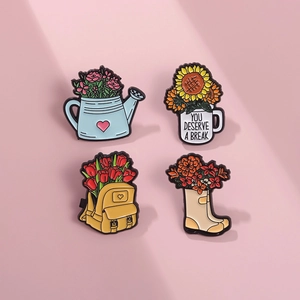 Vue détaillée de quatre pin's émaillés : arrosoir, tasse, sac à dos et bottes de fleurs