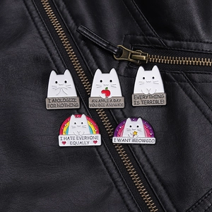 Detailed view of five cute cat enamel pins styled on a black leather jacket lapel