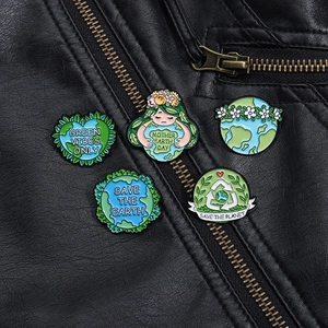 Détail de cinq pin's en émail écologiques aux motifs du Jour de la Terre sur cuir noir