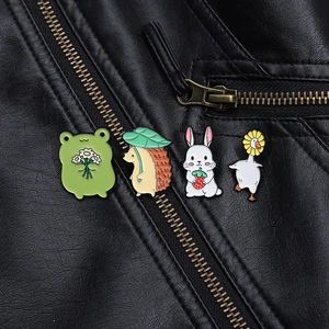 Detailed view of four colorful cartoon animal enamel pins on a black leather jacket