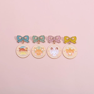 Set of four cartoon animal enamel pins with colorful bows on a pink background