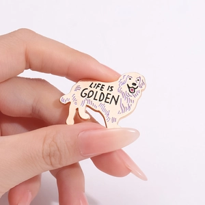 Détail d'une broche en émail Golden Retriever avec texte Life is Golden en main