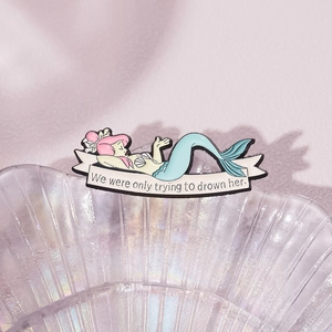 Broche émaillée de sirène dessin animé avec cheveux roses sur un plateau en verre