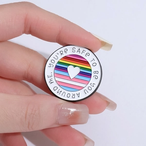 Rainbow pride enamel pin with heart and You're Safe To Be You Around Me text