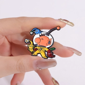 Detailed close-up of colorful enamel Pikmin lapel pins held by hand showing the size
