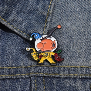 Enamel pin featuring Captain Olimar and colorful Pikmin on a blue denim jacket