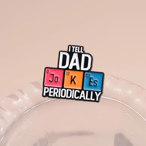 Macro shot of colorful enamel pin featuring 'I Tell Dad Jokes Periodically' quote