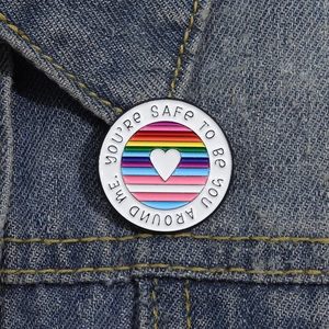 Rainbow enamel pin badge with heart and safe quote on denim jacket collar