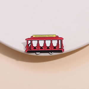 Detailed close-up of a red vintage enamel trolley brooch with polished alloy finish