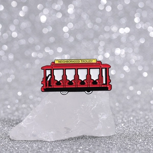 Macro view of Neighborhood Trolley enamel pin with retro red design and metal details