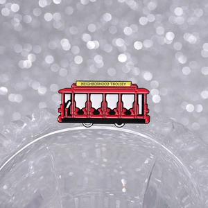 Close-up of a red vintage enamel trolley brooch with Neighborhood Trolley text on top