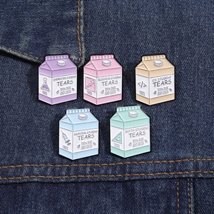 Close-up of colorful milk carton enamel pins with student tears theme on denim jacket