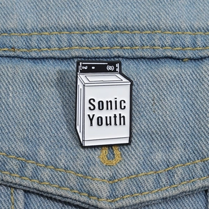 Dettaglio della spilla smaltata Sonic Youth a forma di lavatrice su giacca di jeans
