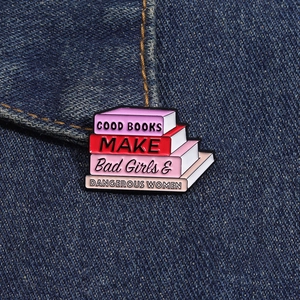 Détail du pin's émaillé coloré avec livres sur denim et slogan d'autonomisation