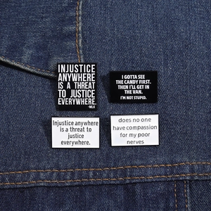 Détail de broches rectangulaires en émail avec citations sur tissu en denim bleu