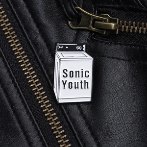 Dettaglio macro della spilla smaltata lavatrice Sonic Youth su una giacca di pelle nera