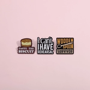 Detailed view of three alloy enamel pins featuring a biscuit, spoon, and music slogans