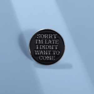 Détail du pin's rond en émail noir avec texte SORRY I'M LATE I DIDN'T WANT TO COME