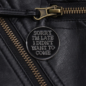 Détail d'une broche ronde en émail avec texte sur une veste en cuir noir