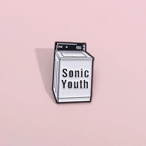 Dettaglio macro della spilla smaltata lavatrice Sonic Youth su sfondo rosa