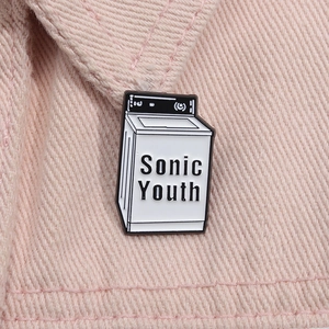 Dettaglio della spilla Sonic Youth a forma di lavatrice su una giacca di jeans