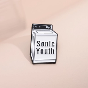 Dettaglio della spilla in smalto a forma di lavatrice con la scritta Sonic Youth