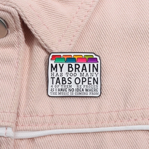 Close-up of browser tab enamel pin with colorful icons on pink denim fabric