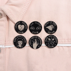 Detail view of 6-piece black enamel pin set featuring Sad Girls Club motifs on a pink jacket